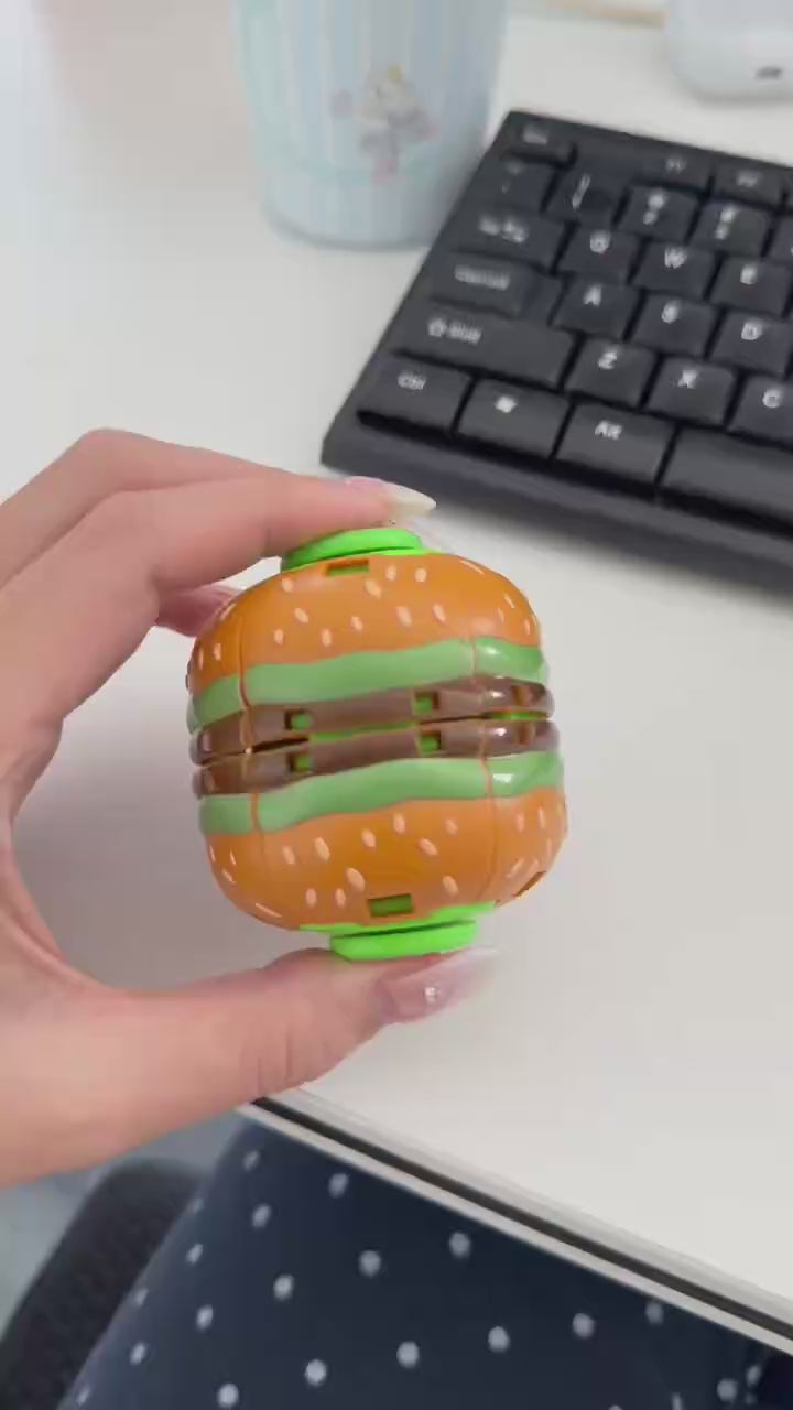 Hand demonstrating how to press and spin a burger fidget ball
